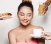 Spa accessories wellness setting with cosmetic bottles and salt with white plumeria flower, blurred massage stones in wooden bowl in background, spa concept, copy space